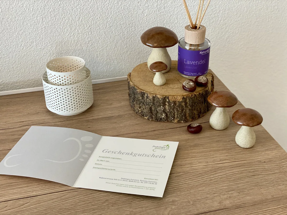 Geöffneter Geschenkgutschein der Podologie Zumstein auf einem Holztisch